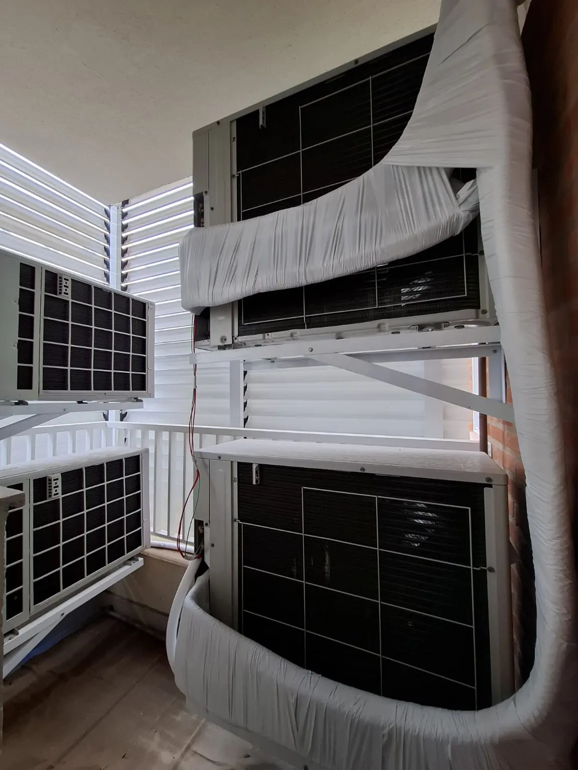 Condensadoras envelopadas e instaladas em rack metálico durante a obra
